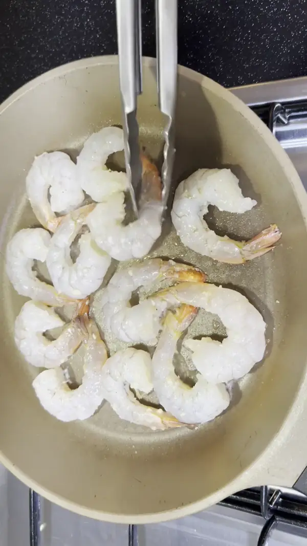 팬에서 새우를 뒤집으며 굽는 갈릭쉬림프 과정